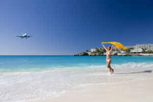 bikini woman at the Caribbean beach with yellow sarong above her head